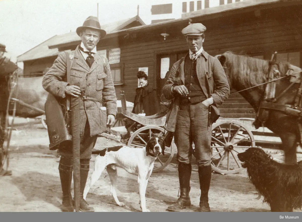 To menn klare for å dra ut på jakt/eller har vore på jakt.
Mannen t.h. er Halvor G. Staurheim, Bø.  Bildet er tatt på Notodden.