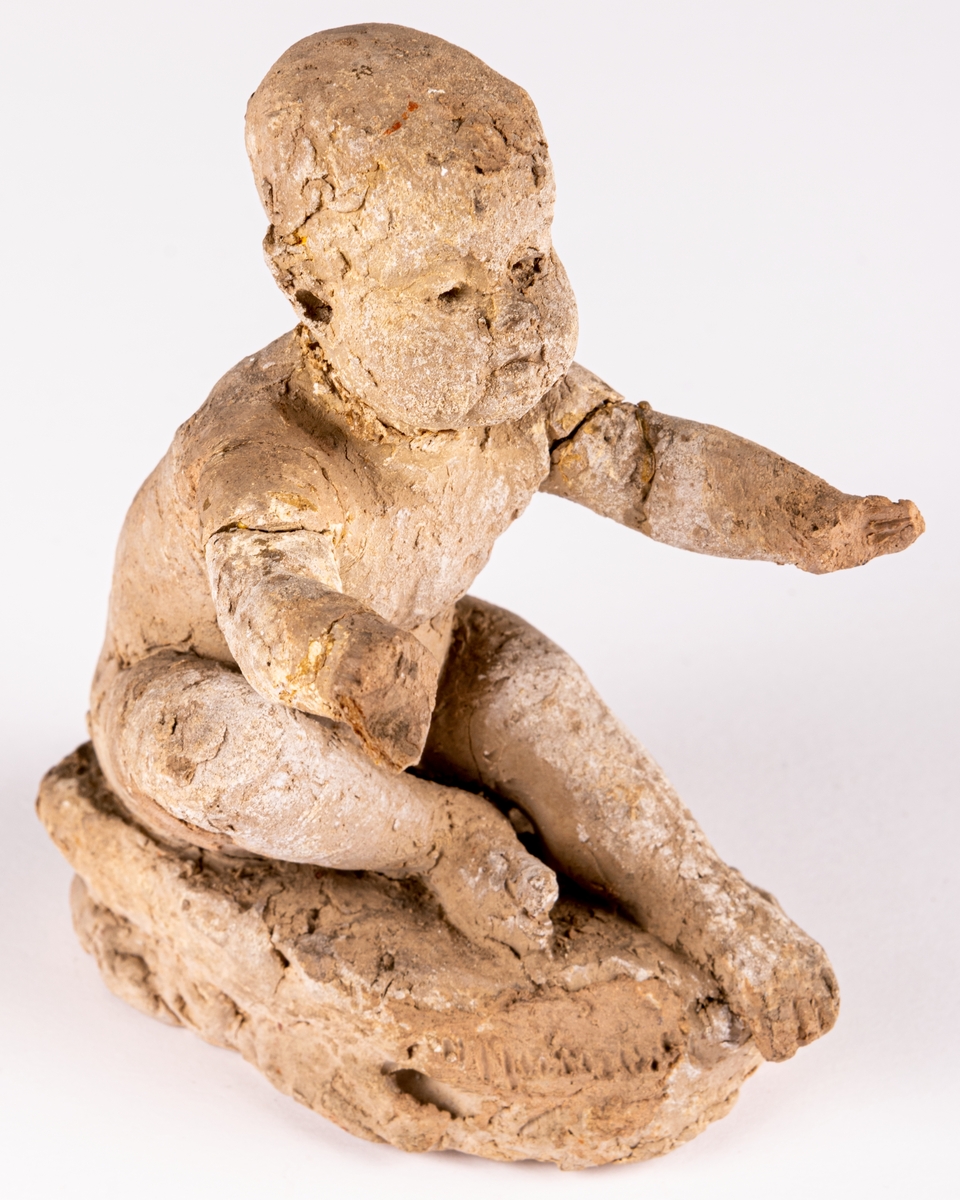 Skiss i terracotta till skulpturen Bebé. Sittande barn med utsträckta armar.