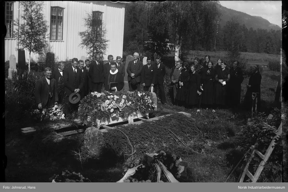 Begravelse for Anne H. Tråer i Gransherad kirke. Mennesker samlet rundt kisten når den senkes i jorda.