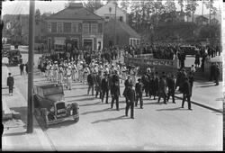 17. mai feiring 1932. Korps marsjerer forbi torget. Biler pa