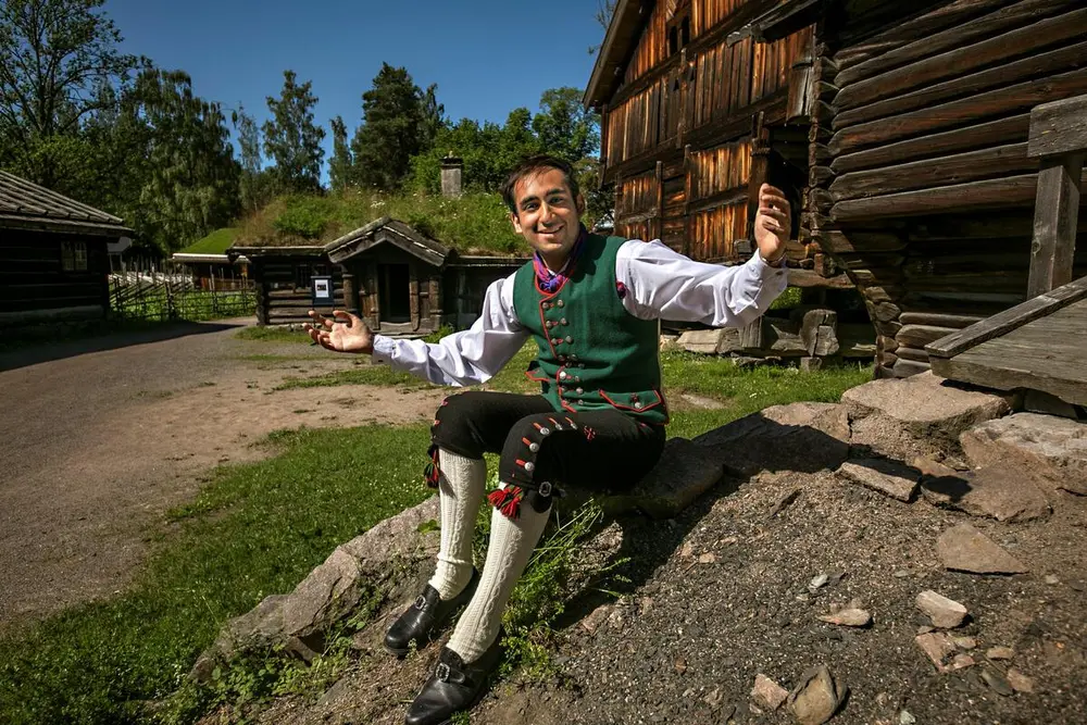 Tunvert i bunad ønsker velkommen til Numedalstunet  på Norsk Folkemuseum