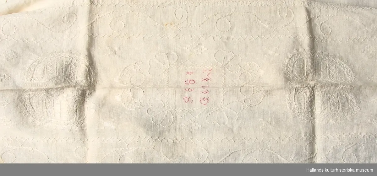 Örngott av linnelärft med broderier vid ena kortsidan. Eftermärkt "MND 1838" i korstygn med röd tråd. Örngottet knytes vid ena kortsidan med två par knytband.