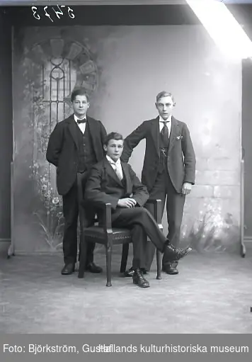 Gruppbild, tre män i helfigur varav en sitter. Ateljébild. Beställare: G. Treffenberg, Falkenbergs Järnväg.