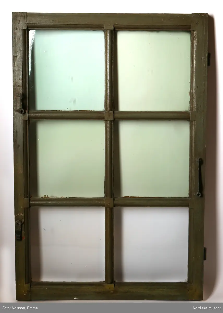 Fönster med karm, fyra fönsterbågar med vardera sex glasrutor, omkring 1740. Utvändigt målat brunt, invändigt grågrön oljefärg. 

Utåtgående fönsterbåge. Träspröjsar med en på insidan rundad vulst som möts i kvadratiskt spröjskryss. Bågens yttersida förstärkt med hörnjärn av 1700-talstyp. Fönsterkarm av furu med symmetrisk korspost. Fönsterbleck av målad plåt, fäst i karmens nederkant. Med fönsterbräda. Beslag för hängning av fönsterluckor. Gångjärn, uppställnings- och stängningsbeslag.  

Anm: Partiellt färgbortfall och skador. Ett av tre fönster, placerat på rummets långsida, mot gatan.
/Anna Arfvidsson Womack 2021-07-14