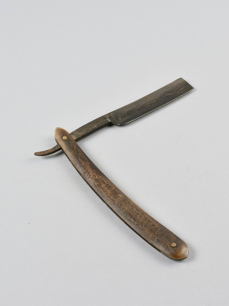 Sammenleggbar barberkniv med stålblad, skaft i horn, holk i messing.