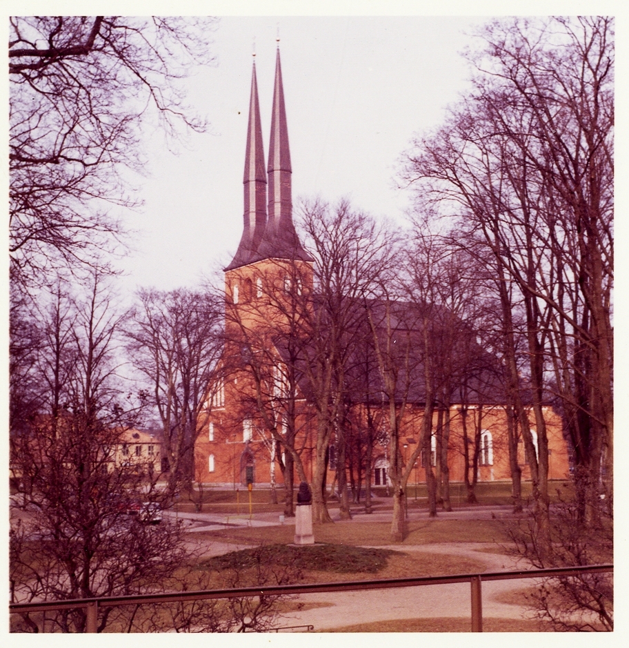 Växjö domkyrka, 1960-tal. Färgfoto. Foto från Linnéparken, med Linnés byst i förgrunden.