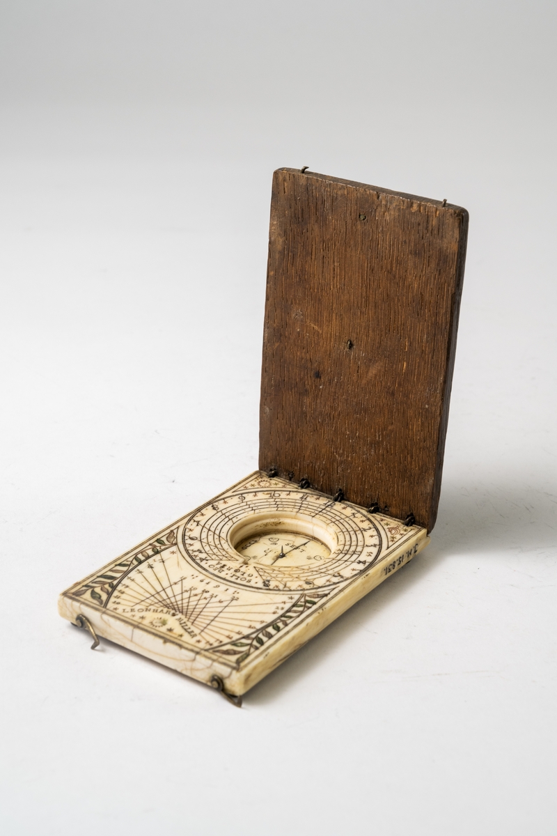 Kompass av ben och trä, tillverkad av Leonhart Miller 1639. Ej komplett. Rikligt skuren dekor på benet. Objektet har formen av en ask med uppfällbart lock.