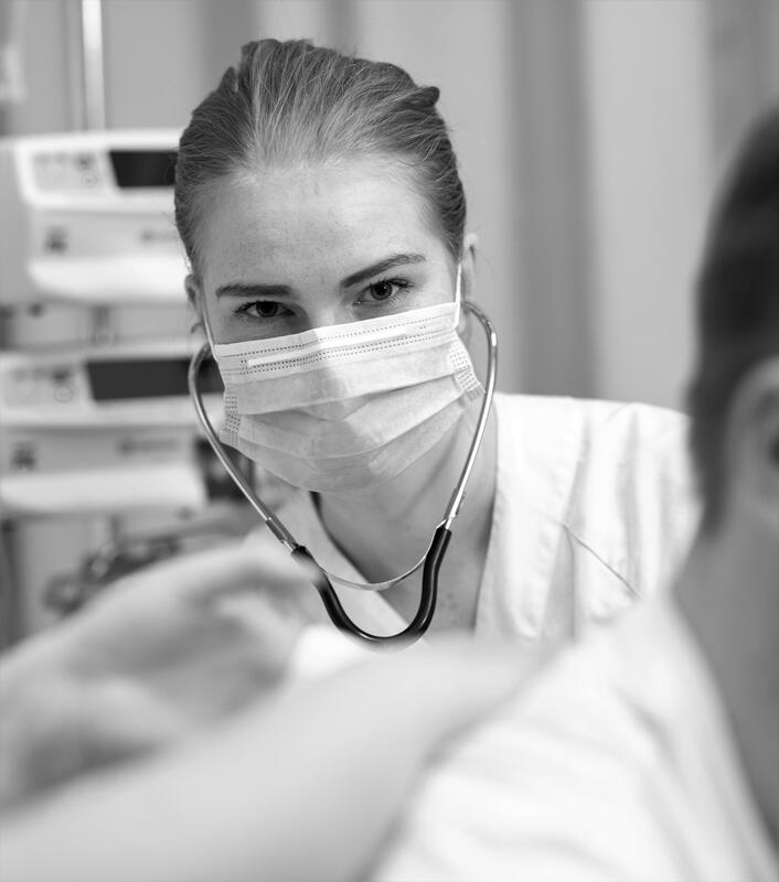 En kvinnelig sykepleier med maske og stetoskop