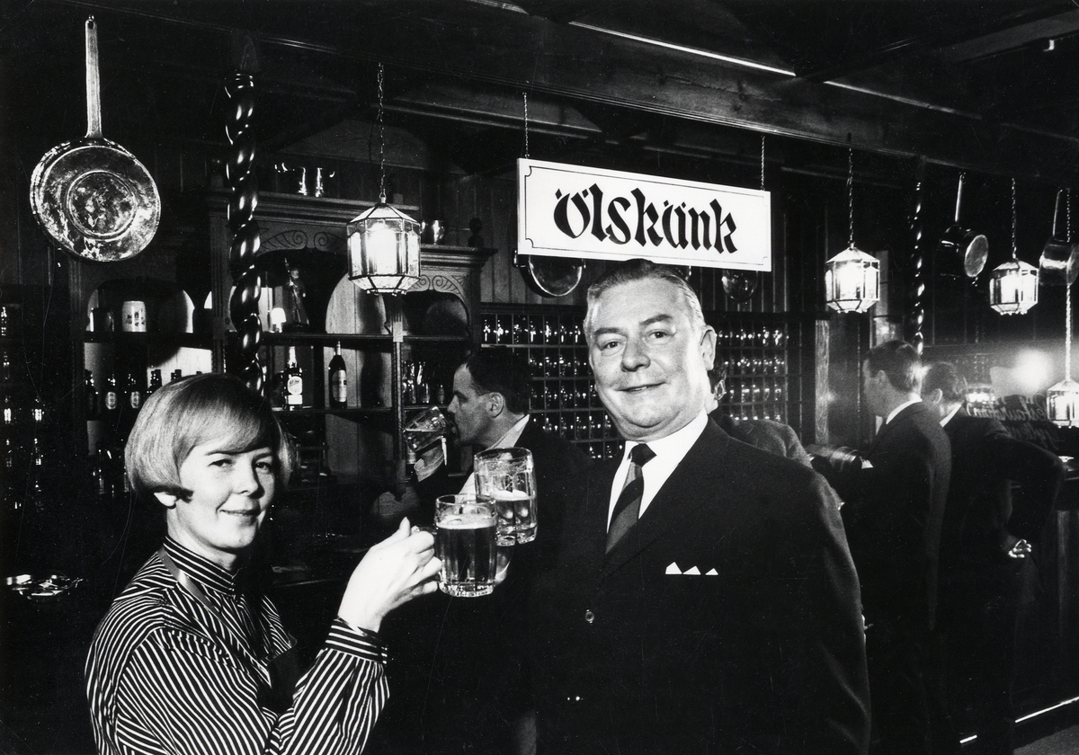 Direktör Gilbert Hedenbergh och fru Svensson skålar i öl för den nya puben Gyllene Oxen på Stadshotellet, Växjö, 1969.