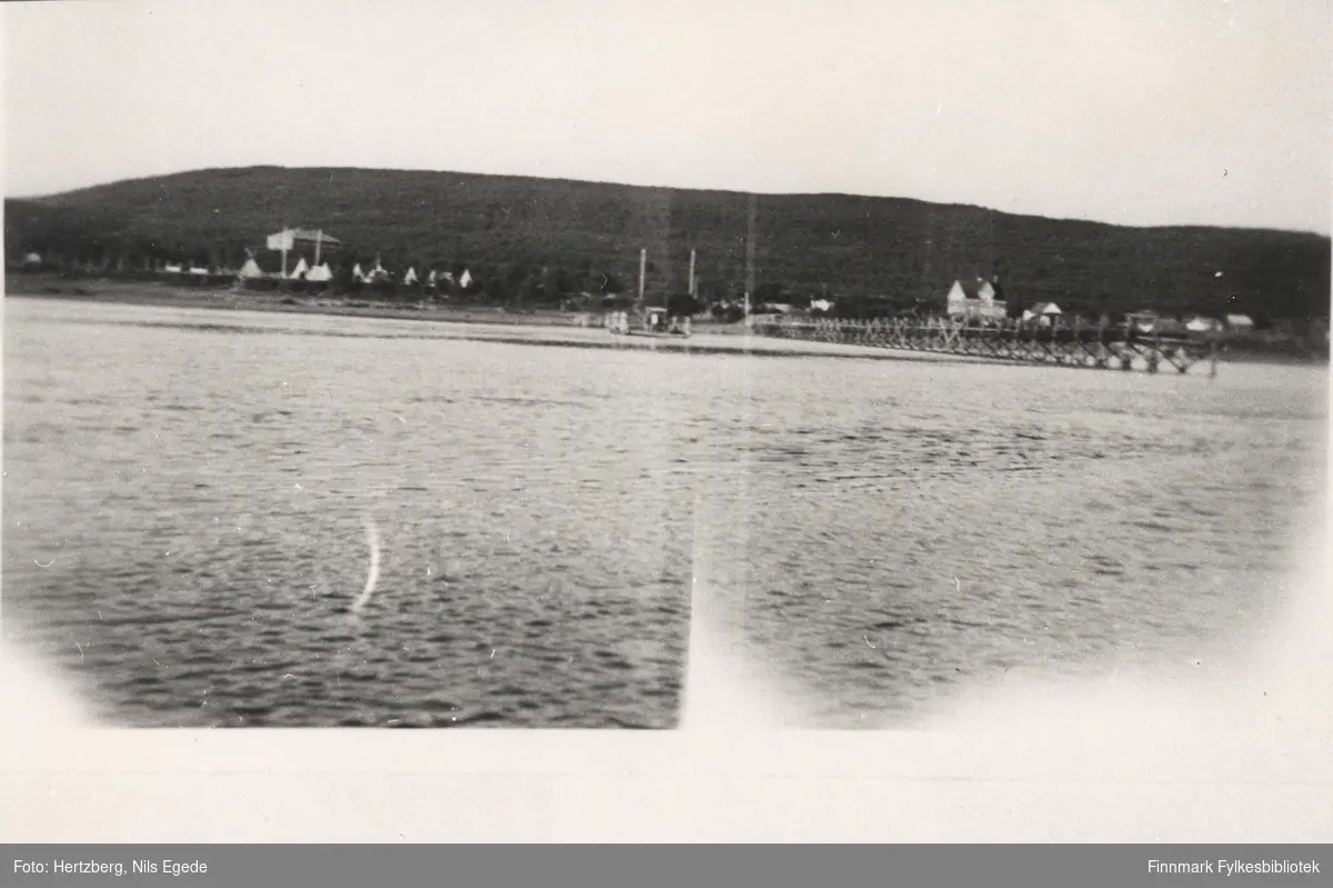 Brubygging over Tanaelven i Seida, 1939. Oversikt over Seida. Leiren til venstre med skoleinternatet i bakgrunnen. Løytnant Tapios hus til Høyre.