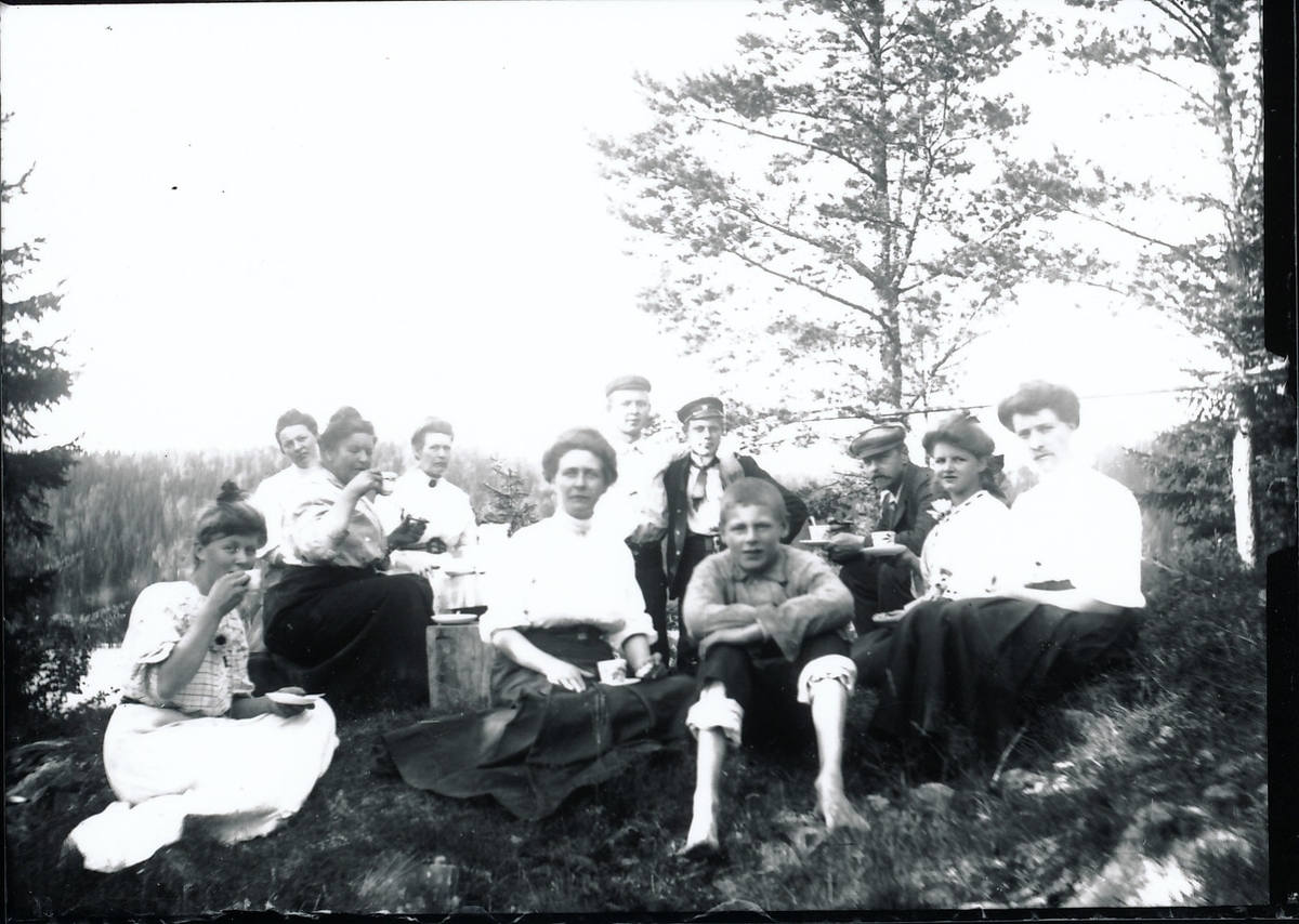 Medlemmer og venner av familiene Rydgren og Berger på skogstur. De sitter på en høyde i skogen og drikker kaffe.