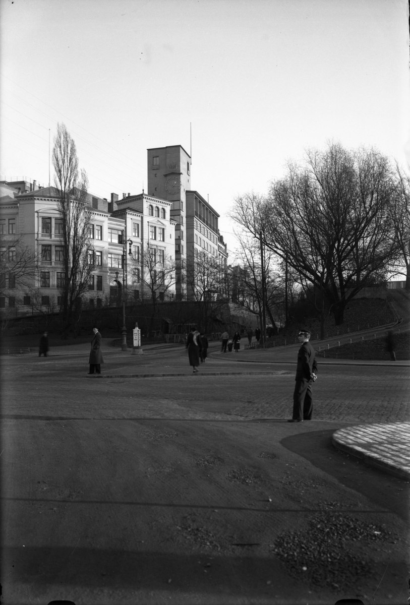 Blikk fra Rolf Stangers plass/ Rådhusplassen mot Rådhusgata. Mann i uniform.