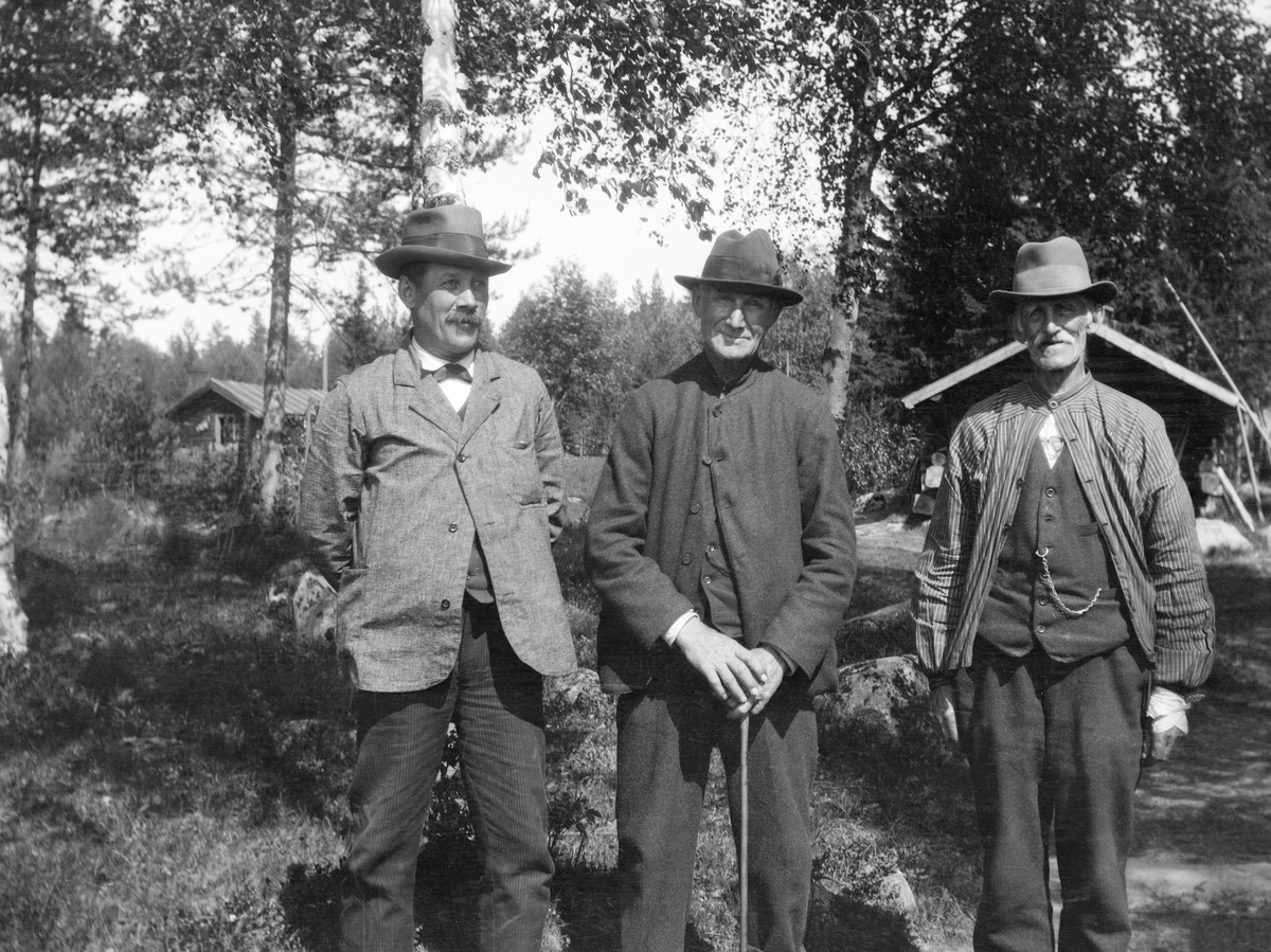 Tre fløterveteranter, fotografert framfor koia ved Grundsetfossen i Elverum våren 1920. Fra venstre ser vi Martin Andersen Bolstad (1871-1952), Per Embetsen Fossum (1846-1925) og Peder A. Kjeljebakken (1847-1926).