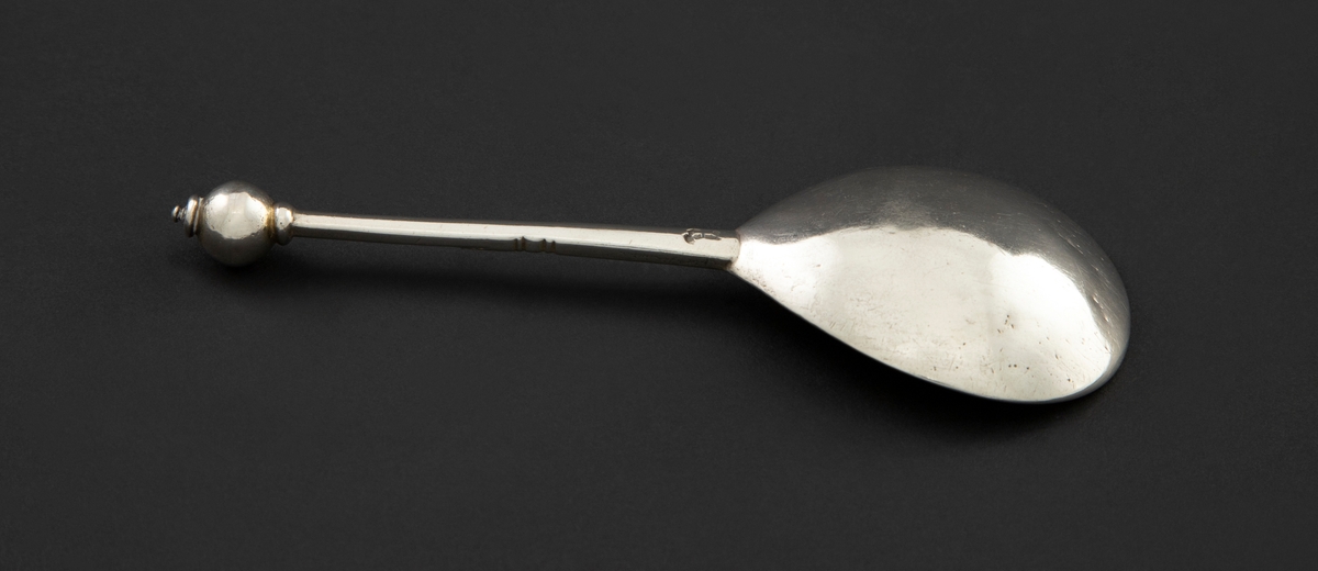 Delvis forgylt kuleskje i sølv med dråpeformet blad og femkantet skaft. Innsiden av skjebladet er dekorert med akantusornament.