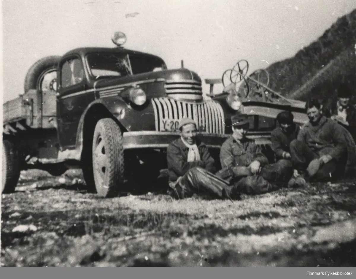 Vedlikeholdslag. Veghøvel og Chevrolet lastebil 1946-47-modell. Nr. 2 fra venstre er sjåfør Karl Labbahå. De fire andre mennene er ukjente. Sted er Brannsletta, Bugøyfjord.