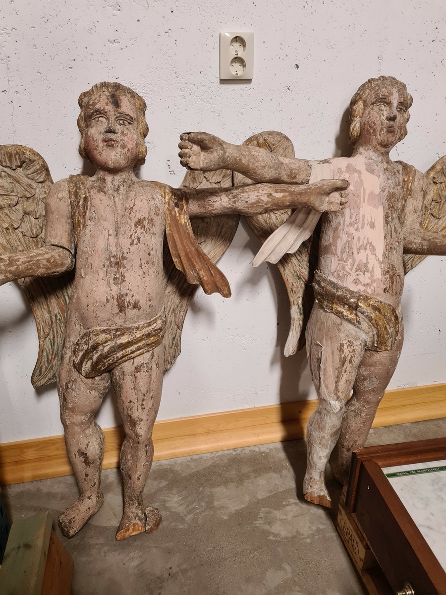 Två skulpturer i form av änglar. Bemålade.
Dessa har använts som ljusstakar där de hållit ljus i händerna samt ett på huvudet.

Den ena ängeln är delvis rengjord och fått delvis en grund mellan de färgade partierna. Denna har konserverats och den senare grunden har avlägsnats. (2021)
