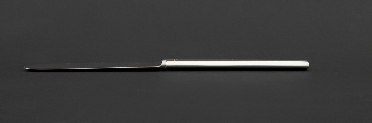 Liten kniv i sølvplett. Ovalt skaft med rett avslutning og bredere knivblad. Fra bladets halvrunde avslutning er egg og rygg parallelt.