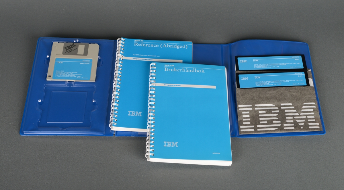 En plastperm med installasjonsprogram for IBM DOS. Inneholder én 3,5-tommers diskett og to 5,25-tommers disketter som ligger i pappbeskyttelse. Permen inneholder også to brukermanualer, én på engelsk og én på norsk. Hovedfargene på permen er er grå, blå, og sort.