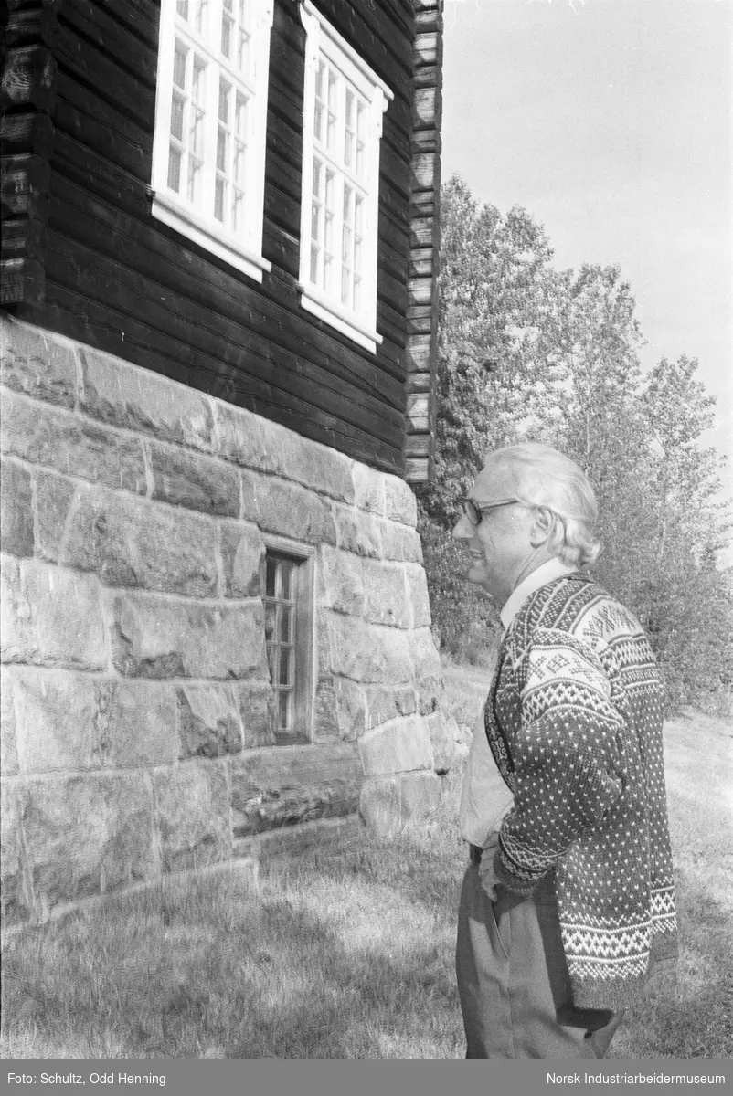 Mann ved grunnmuren til laftehus i Øyre Gjøystdal.