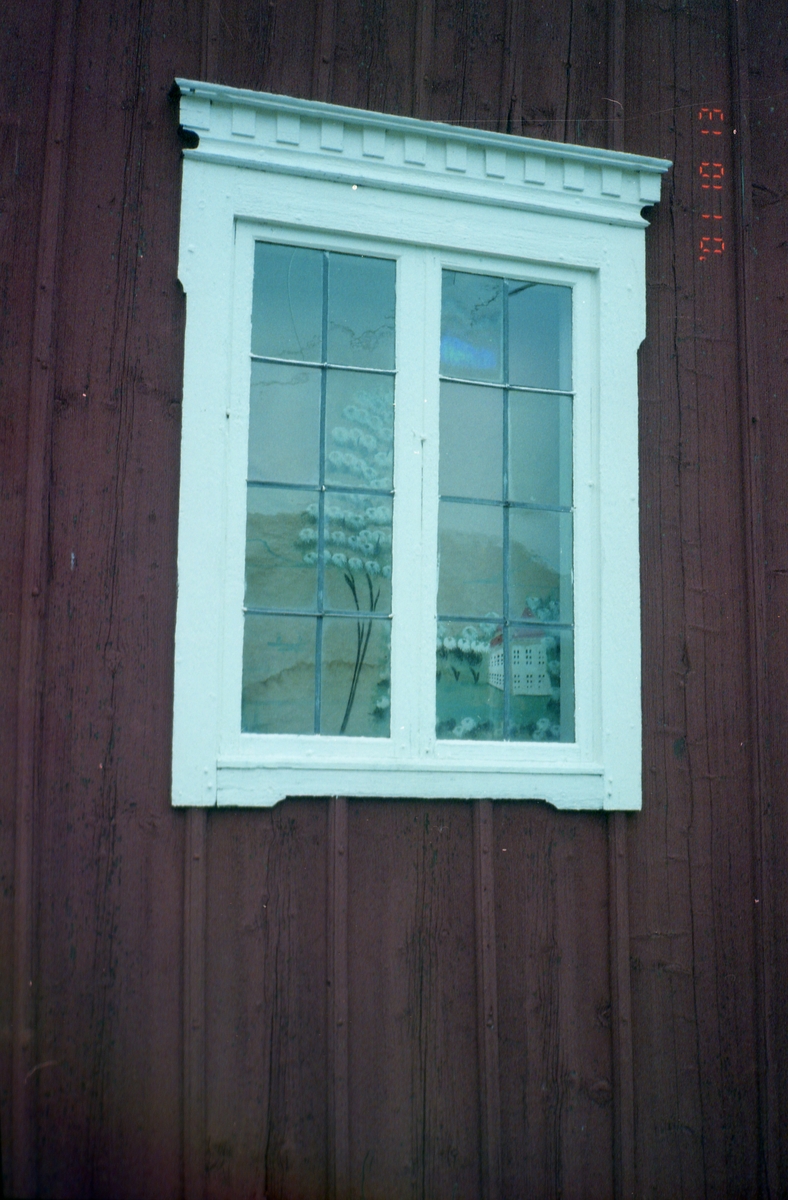 Trähus med spröjsat fönster där det hänger en schablonmålad rullgardin, 13 oktober 2001.