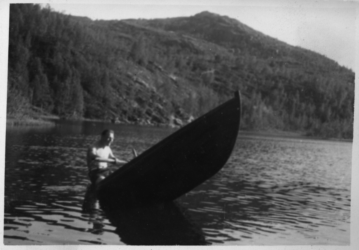 Mann ror en halv båt på Øvstevatnet i Salangen.
