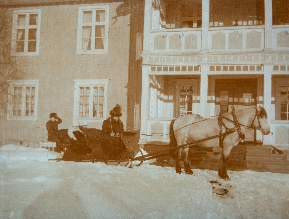 Hest med slede, vinter. Ottestad Gård, Stange. Eli Cesilie Gjestvang sitter med kjørepisken, med 3 av barna sittende bak på sleden.