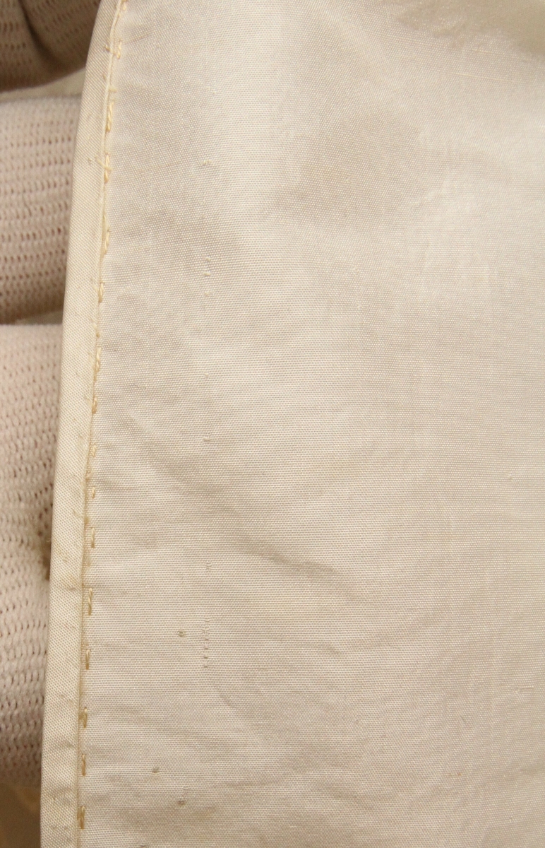 Sjalet er sydd sammen av fire deler og er håndsydd, forkanten har smalt belegg av samme slags stoff. Hele plagget er formklippet for å henge godt over skuldrene. Innerste kant er tunge silkefrynser og likeså er det silkefrynser midt på langs det hele. Langs den øverste frynse er sydd kreppet bredt silkebånd, nå løsnet, men det har tjent som en form for strikk.