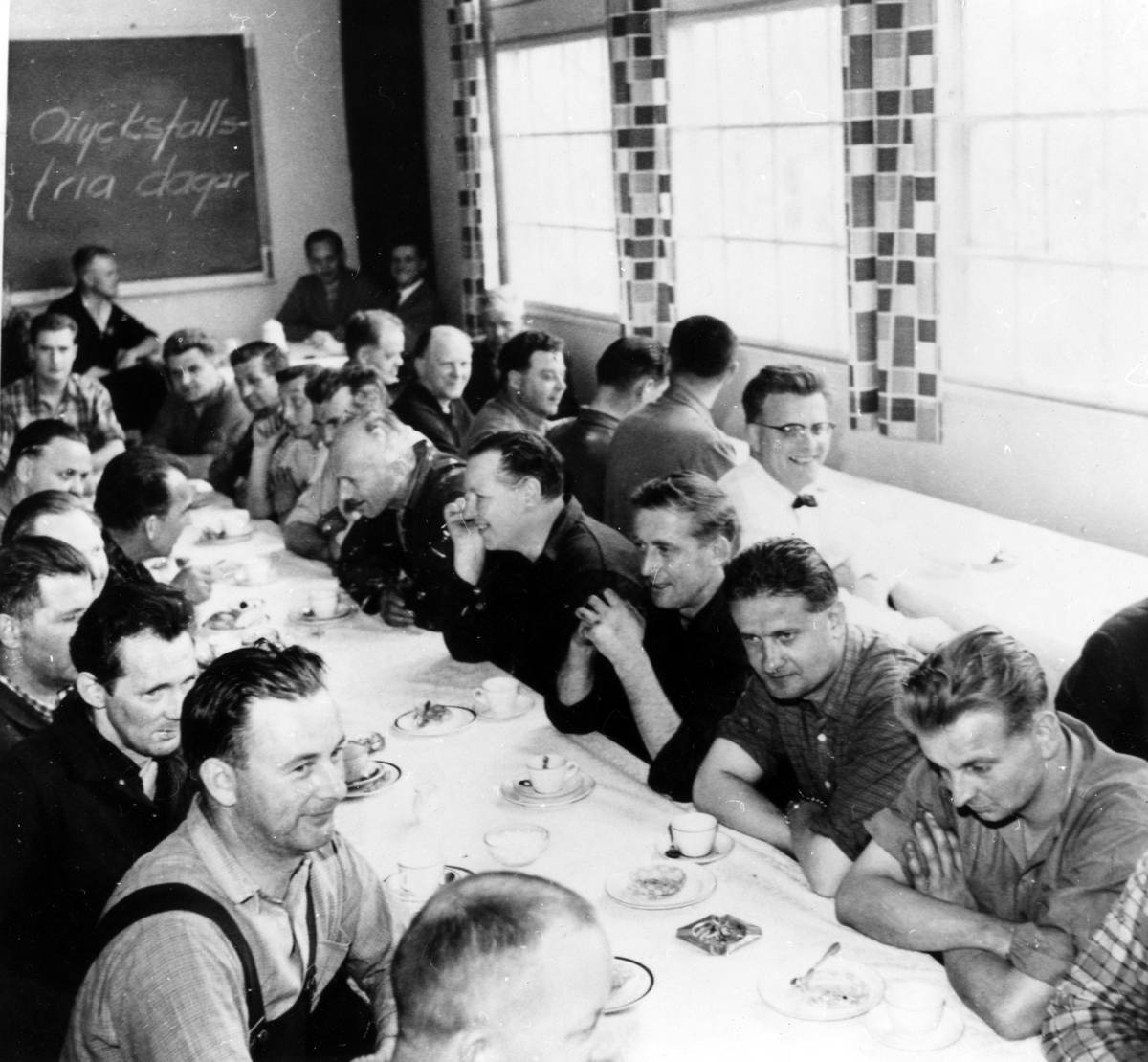 Matsalen på Alingsås Electro Apparat efter att Electro-Helios tagit över 1960. Män sitter bänkade längs bordsraderna och firar 250 olycksfria dagar med kaffe den 27 maj 1965.