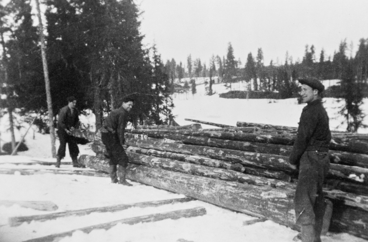 Tre personer foran en tømmerlunne på Flishøgda, Elverum, Hedmark.