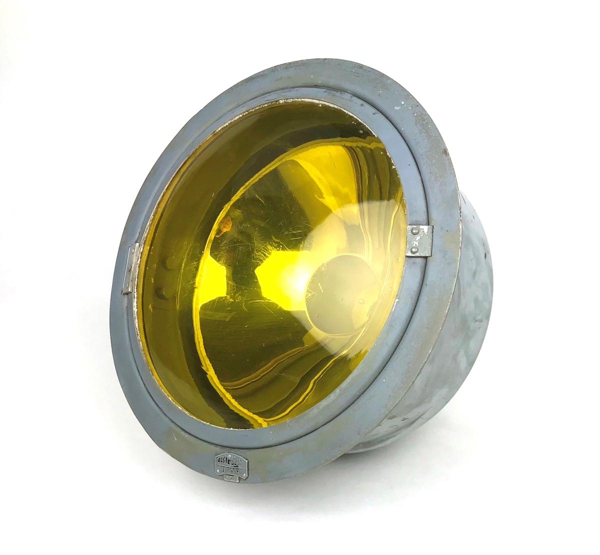 Landningsljus tillverkad av Carl Zeiss, Jena, Tyskland. Hölje av metall, gult glas, insats försilvrad. Lamphållare saknas.