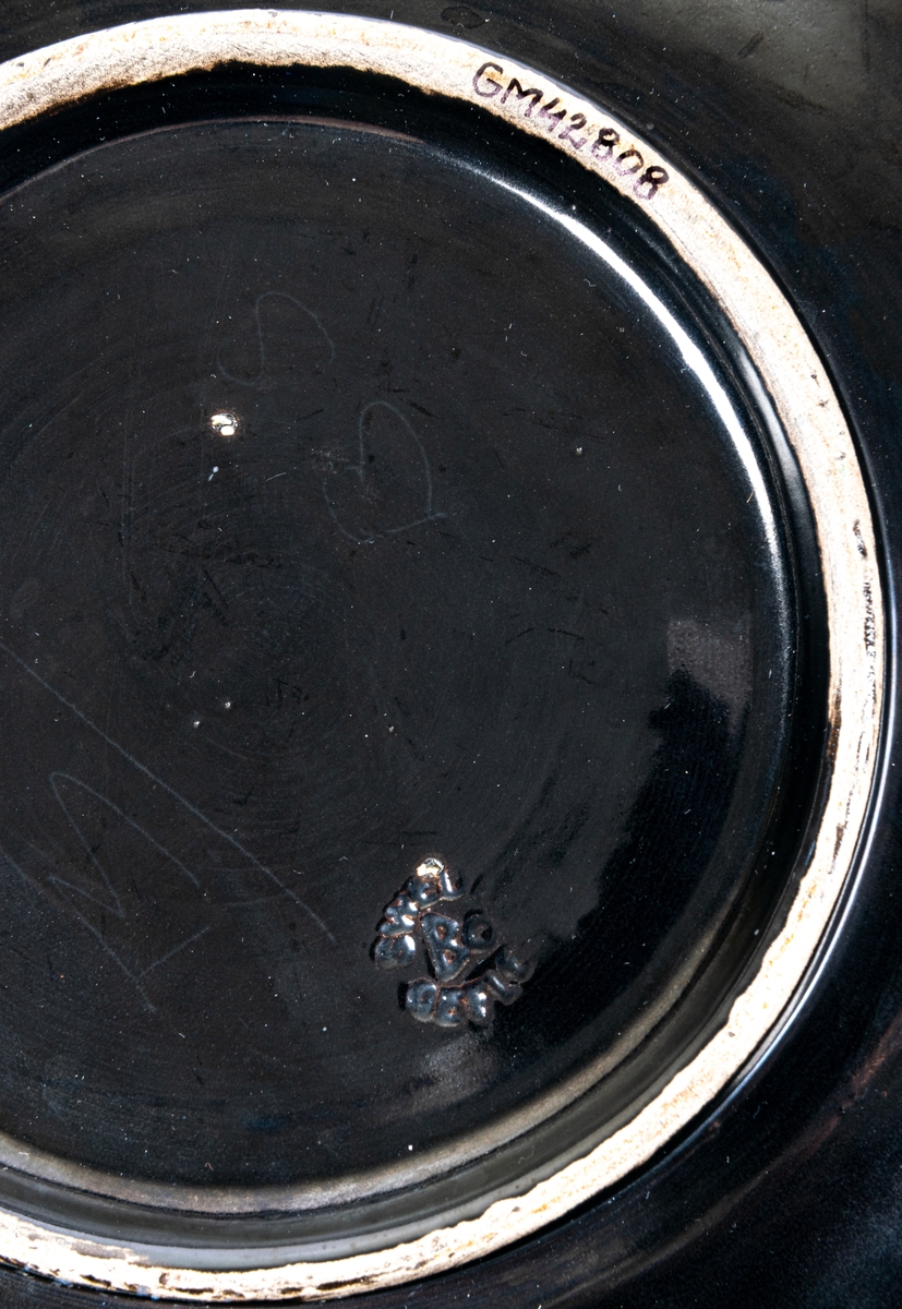 Stort svartglaserat fat, kallat "fyrklöverfat", av lergods, av Ewald Dahlskog, Bo Fajans. Modell D1.