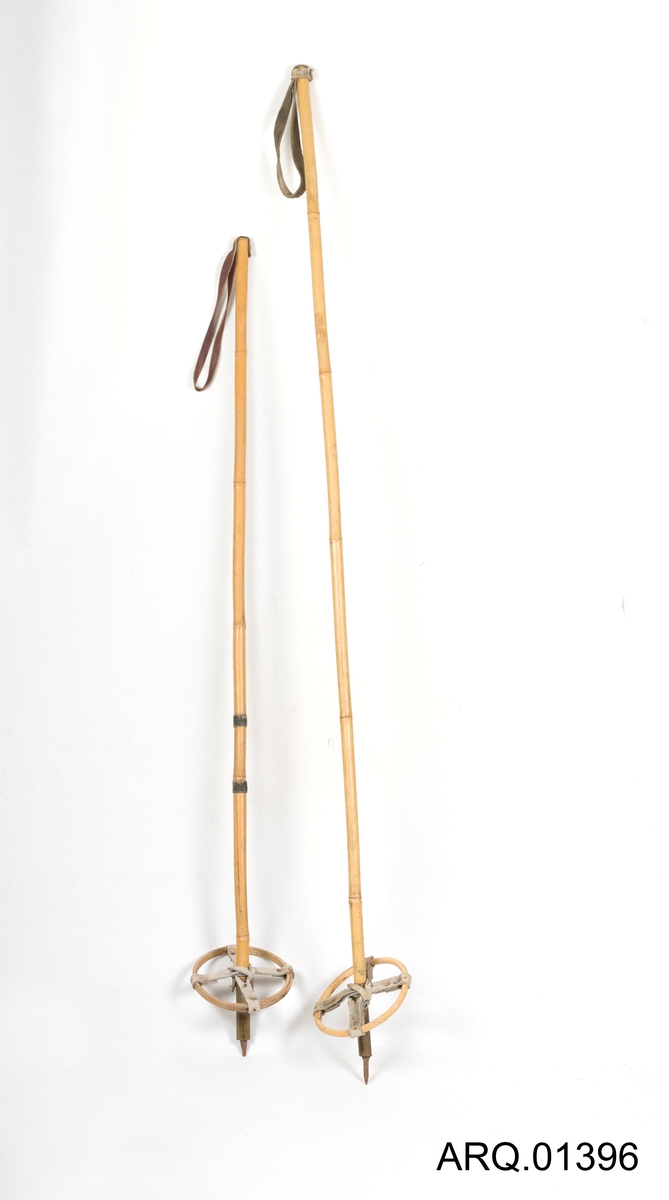 Skistaver, ett par laget av bambus. Skinnreim til å holde i og skinn nede på trinsen.