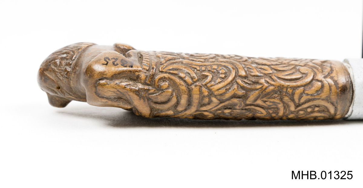 Treskjæring håndtak med akantus roser og figuren av en løve skåret i øvre ende.