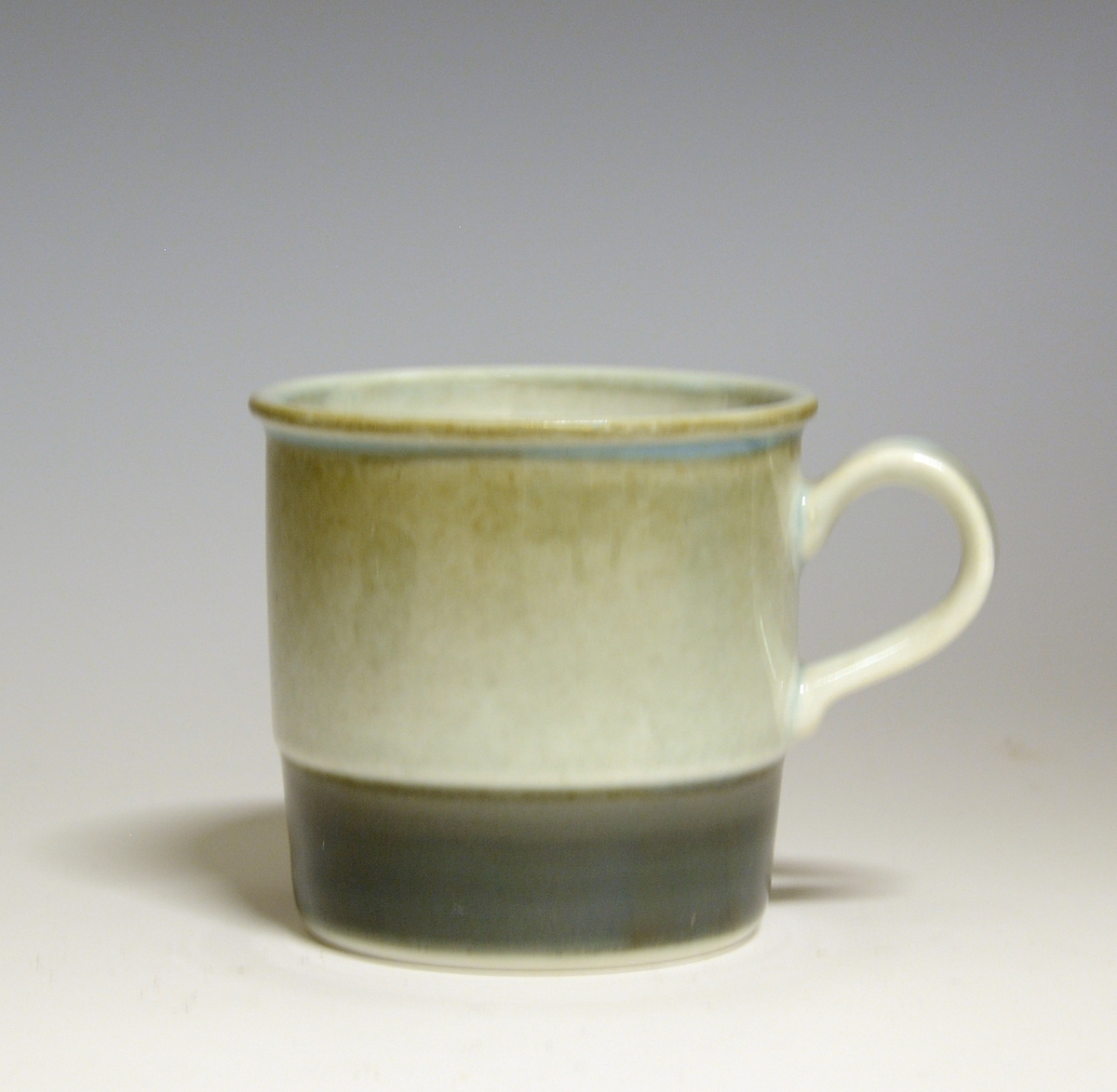 Kaffekopp av porselen. Nederst en bred grønn stripe.
Modell 444/1 Eystein
Dekor: 88306 Tundra