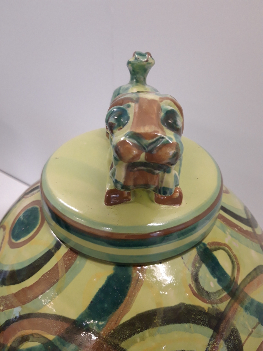 Bojan eller urna med lock, cirkeldekor på grönbrun glasyr på gul botten. Lock med djurfigur/tempelhund. TIllverkare Bo Fajans, formgiven av Allan Ebeling.