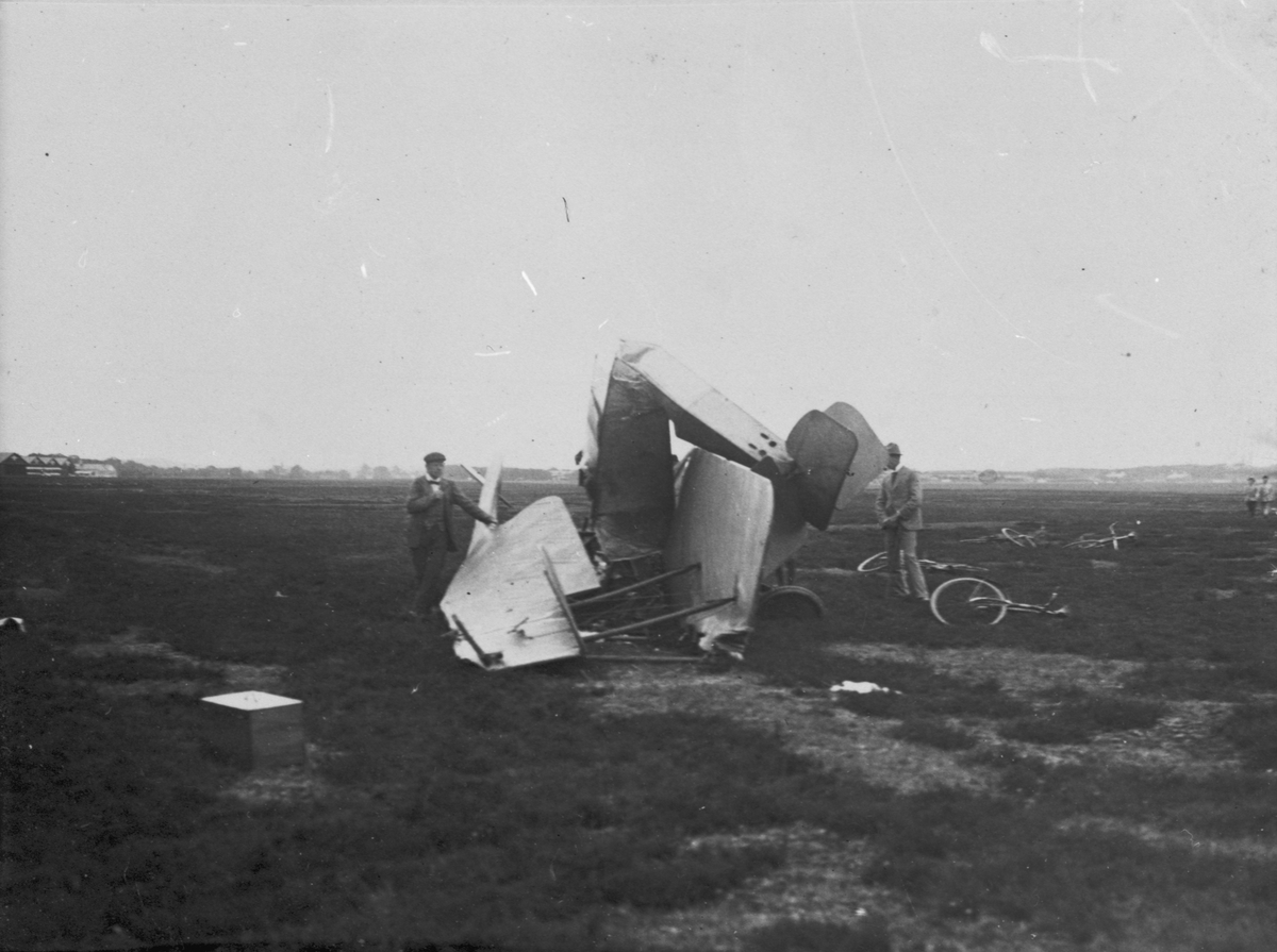 Vraket av flygplan Thulin E efter haveri på flygfältet i Ljungbyhed 20 juni 1919. En man står bredvid flygplanet.