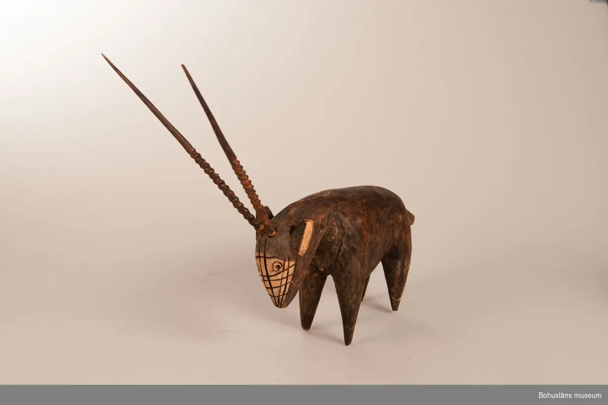 Ur handskrivna katalogen 1957-1958:
Träskulptur; antilop?
H. (utan horn) 16 cm.
längd- och tvärstrimmig på huvudet. Ben trasiga, lagade. 
Hornen b och c, L. 23 cm. hela. 
Infödingsarbete, Sydafrika.

Lappkatalog: 9