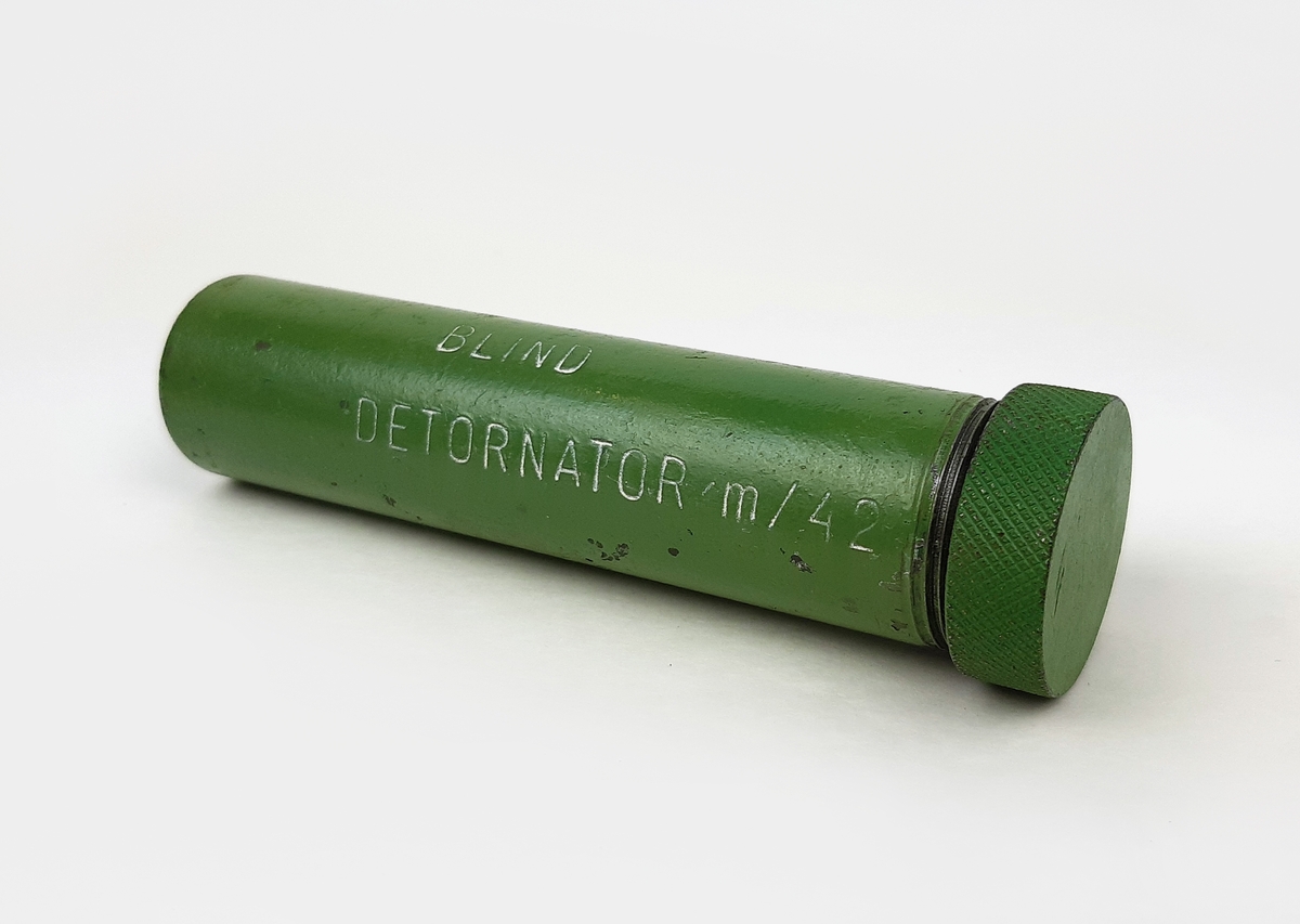 Detonator m/42, blind. Bestående av en grönmålad cylinder i metall med skruvbart lock.