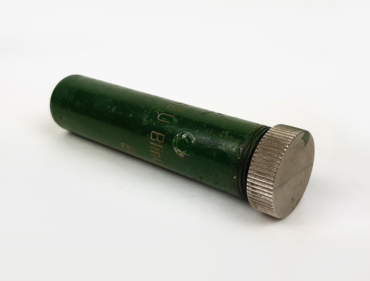 Detonator m/42 U, blind. Bestående av en grönmålad cylinder i metall med skruvbart lock. Ena kortsidan med gul märkning.