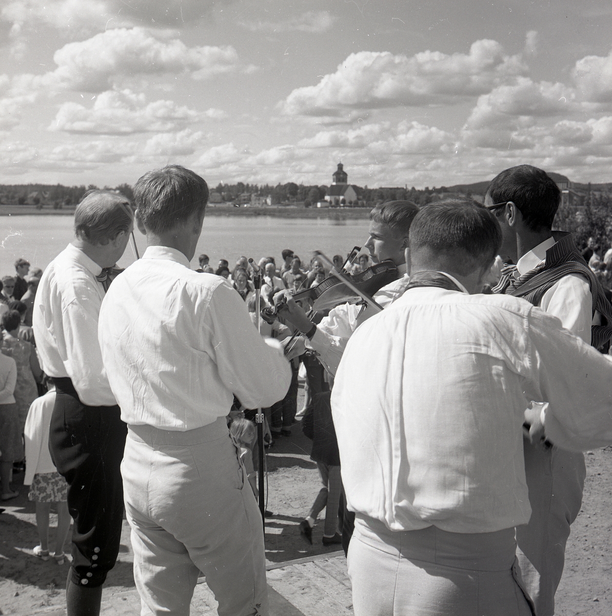 Spelmän och publik vid Vågens strand i Bollnäs under Hårgadansen, 13 juli 1968. I bakgrunden syns Bollnäs kyrka.