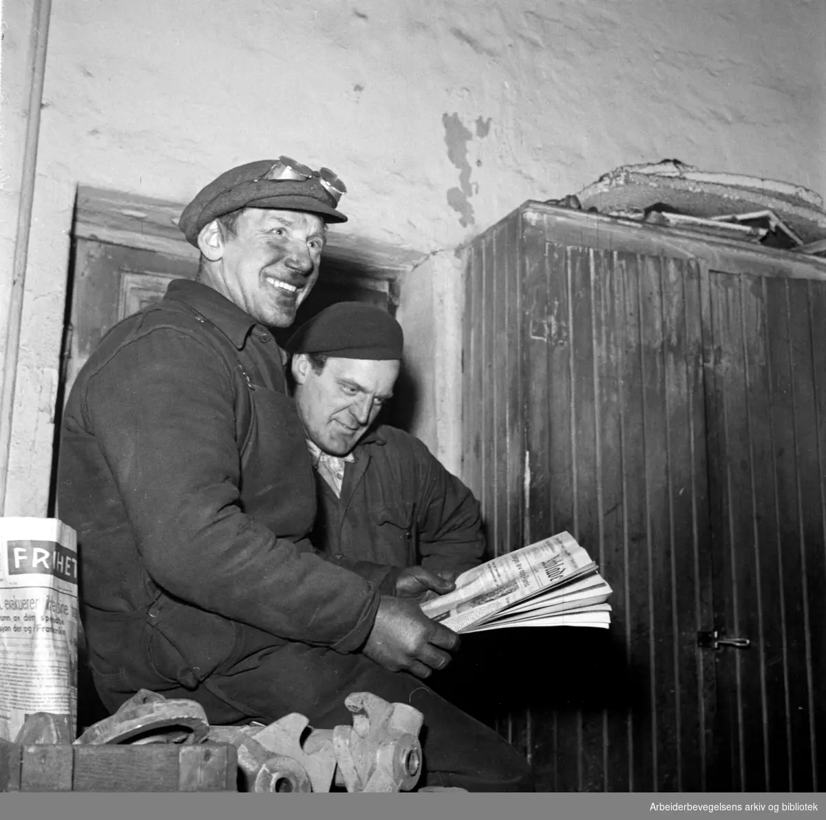 Reklamekampanje for Arbeiderbladet. Verkstedarbeidere leser avisen. Fotografert for reklameavdelingen. Desember 1947.