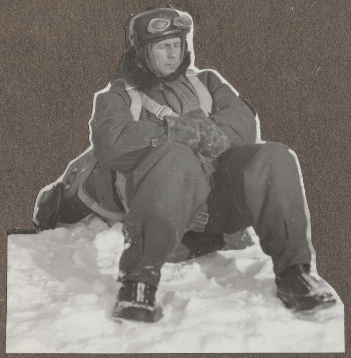 En militär flygare sitter i snön.

Text vid foto: "'Lorichs"