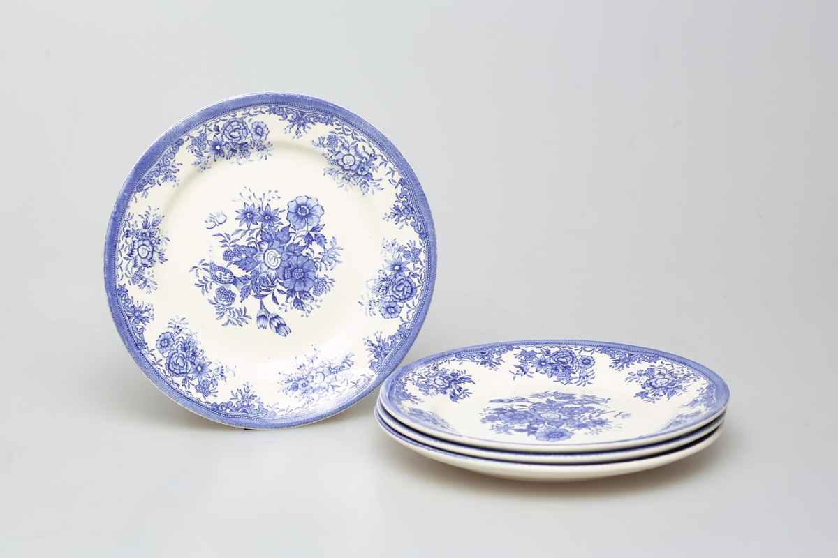 Fire hvite tallerkener dekorert med blått fasanmønster.