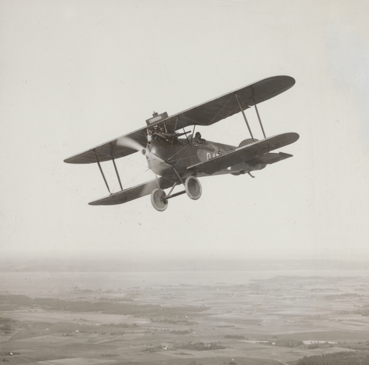 Flygplan Phönix D.II Phönixjagaren märkt nummer 949 flyger över landskap, 1925. Flygbild med sjön Roxen i bakgrunden.

Text vid foto: "Phönixjagare. 185 HK. B.M.W. eller 200 HK Hiero. Över Roxen. 1925."
