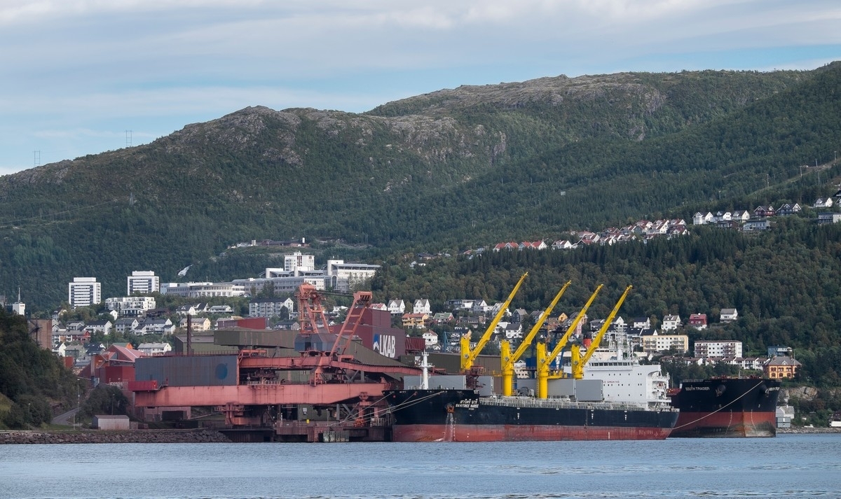 Malmskip laster ved kai 5 (nærmest) og kai 7 ved LKABs anlegg i Narvik. Midt på bak sees Universitetet, campus Narvik, og til venstre boligblokkene Tøtta 1 ogh Tøtta 2.