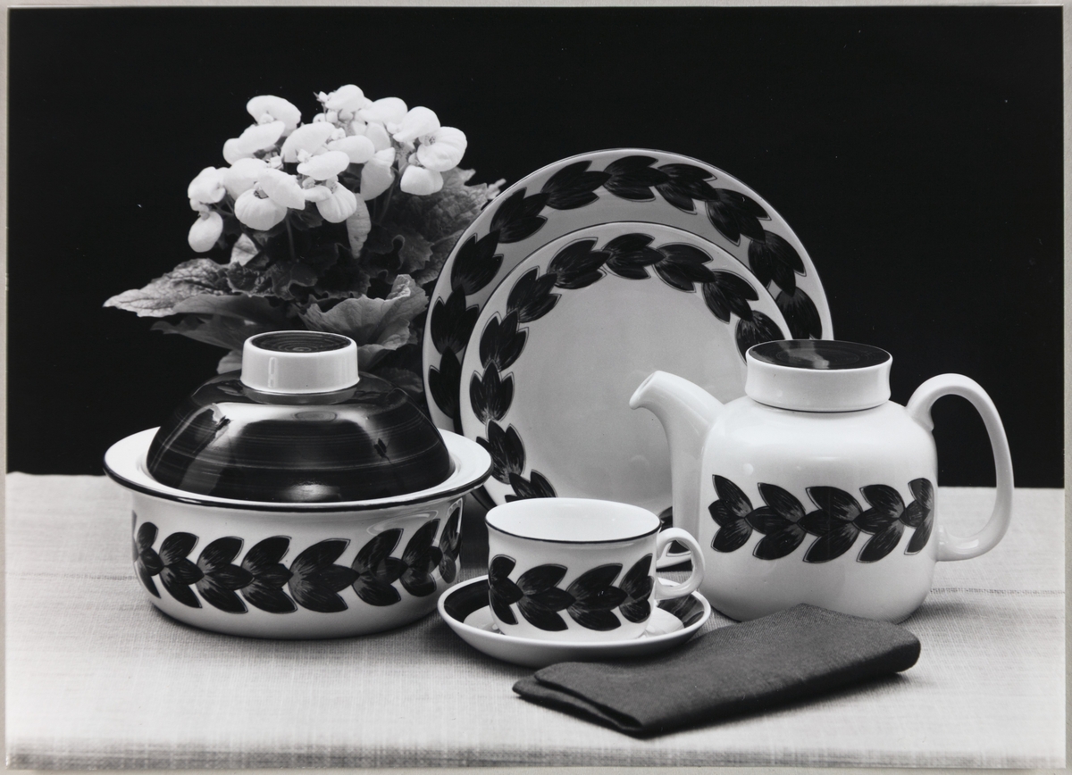 Servise med dekoren "Karin" fra Figgjo Fajanse - Stavangerflint A/S. Avbildede objekter viser en tekanne, lokk-fat, tallerkener i ulike størrelser og kopp med underskål. 