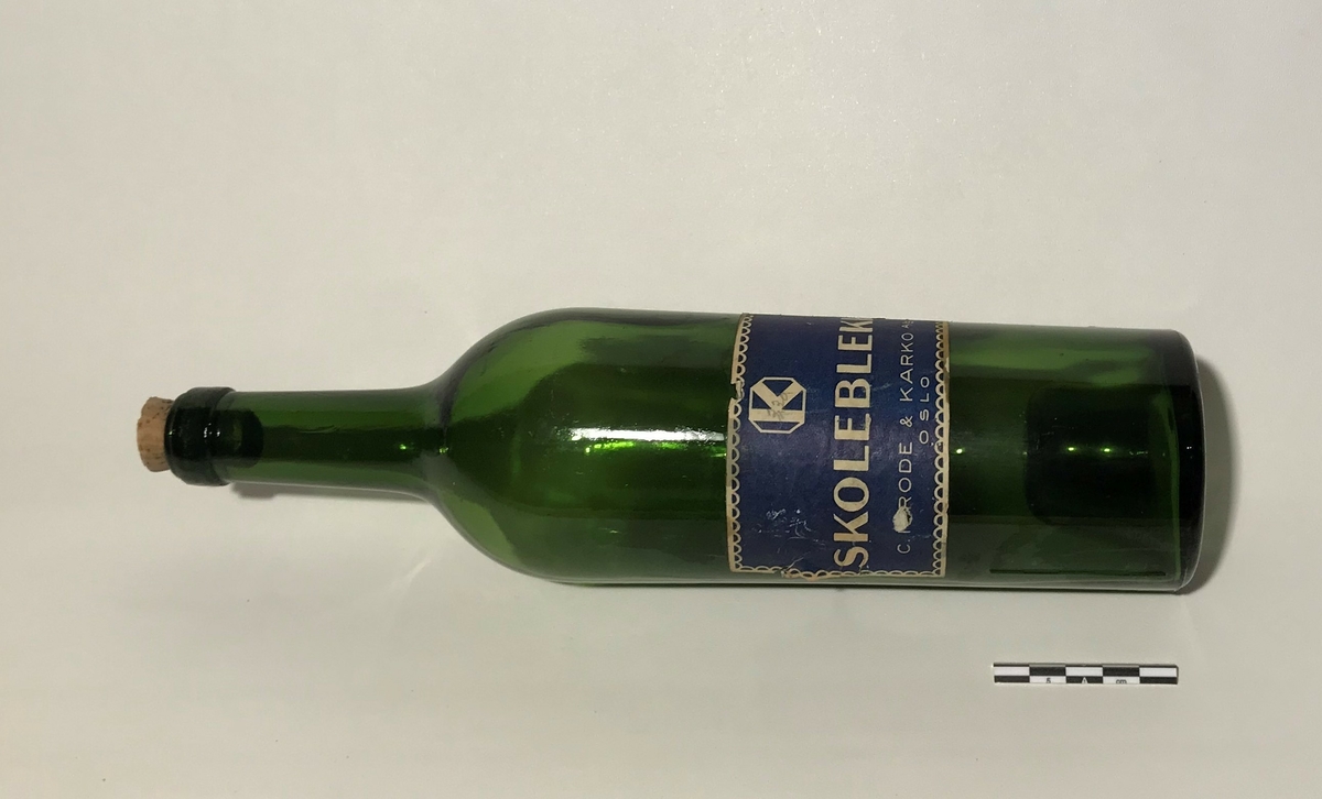 Grønn glassflaske for oppbevaring av blekk. 