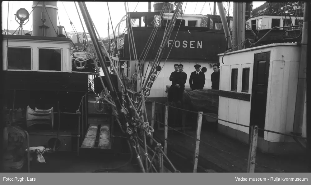 Flere dampbåter samlet. På dekket til båten "Fosen", står det fire sjømenn. 