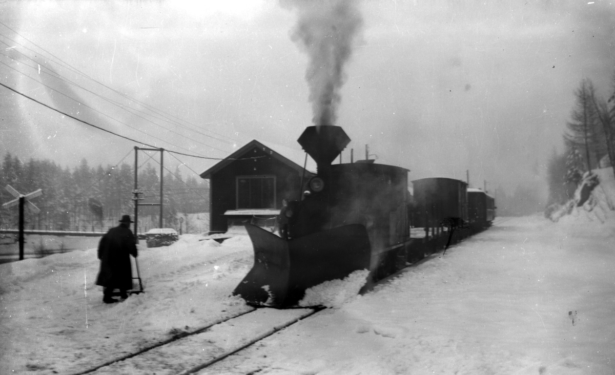 Setesdalsbanen.  Godstog og lok nr. 5 ved Røyknes stasjon, februar 1961. Mann som måker plattformen.