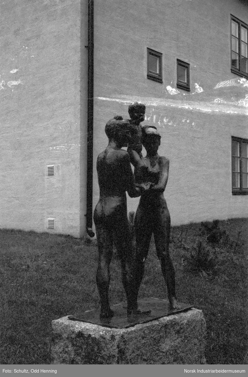 Skulptur av to mennesker som holder et barn, ved Eldres hus på Rjukan.